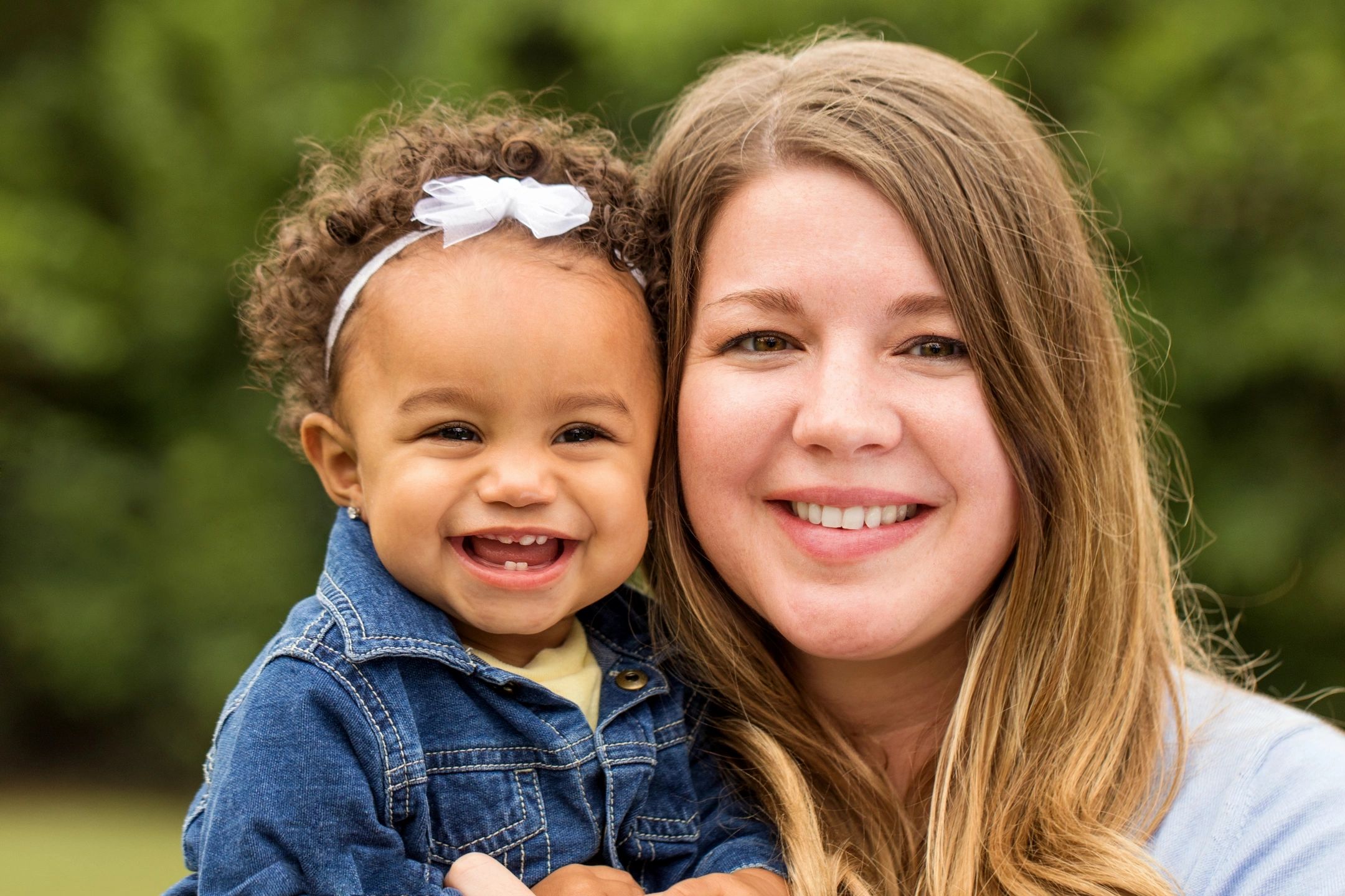 Picture of caucasian woman and African american little girl smiling and happy. Grace Place, Sumner County provides Education and Training Help to Break Cycles of Poverty