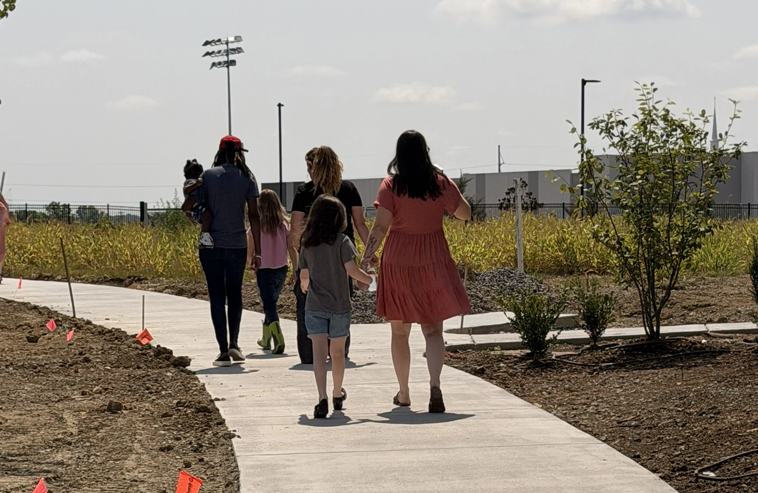 Family walking together along a new pathway at the Grace Place community campus
